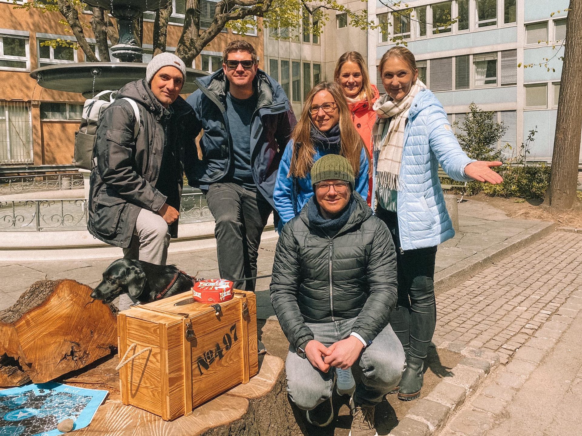 Équipe qui pose avec le coffre au trésor ouvert à la fin d'un escape game en plein air sur mesure